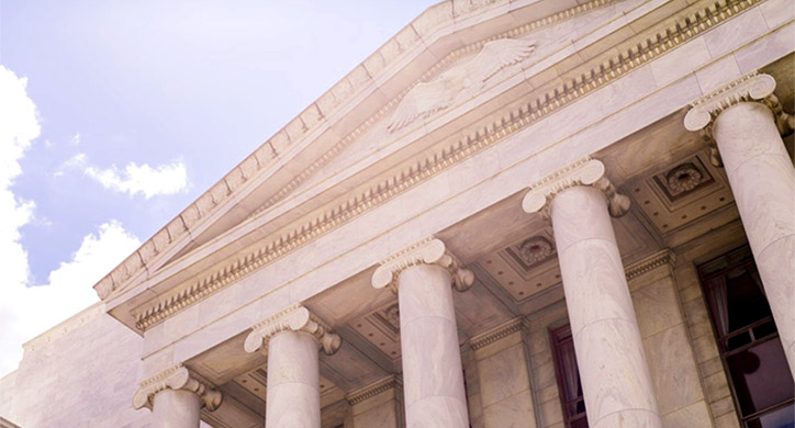 looking up at a government building with blue sky above